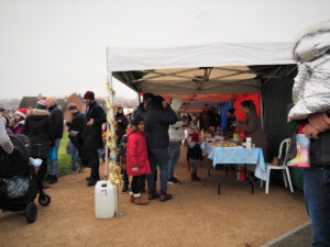 A a long row of marquees with crowds of people in front of them