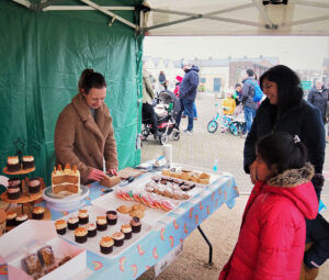 A table with assorted cupcakes, with people looking down at them