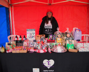 A woman standing behind a table full of Christmas presents