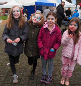 A group of four face-painted children