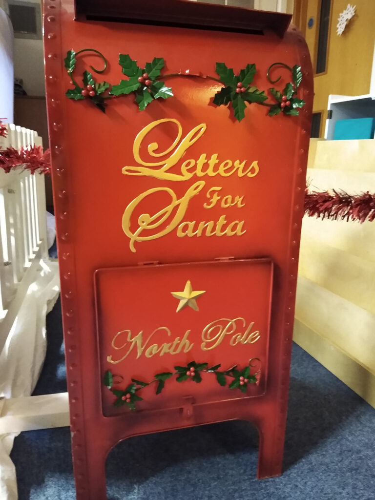 A red mailbox with 'letters for Santa' written on the front in gold