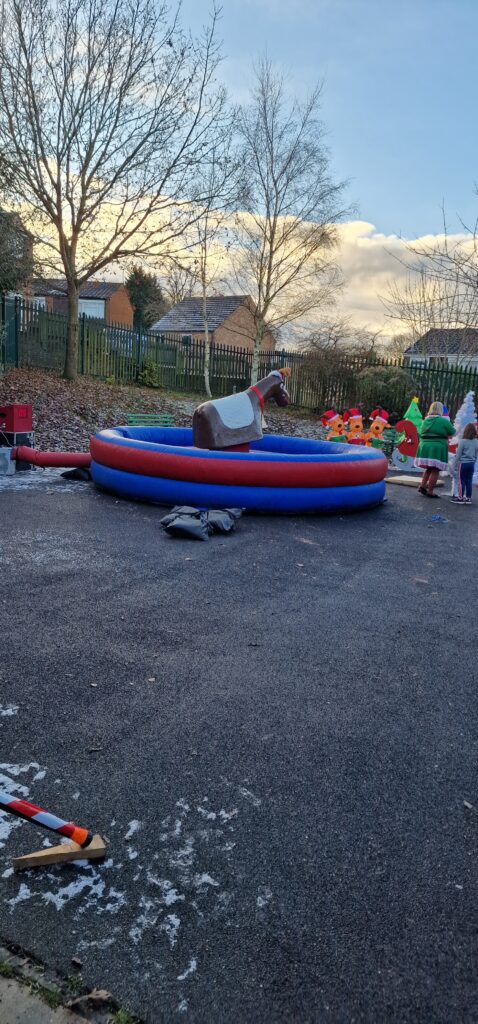 A photograph of a 'bucking reindeer' ride, with an inflatable ring around it