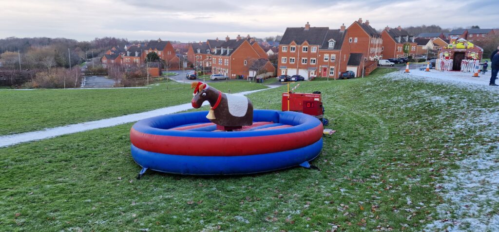 A photograph of a bucking reindeer ride, sited on the grass
