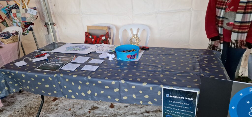 A table labelled "Angel Hope Lawley", with various leaflets and pieces of paper arranged on it