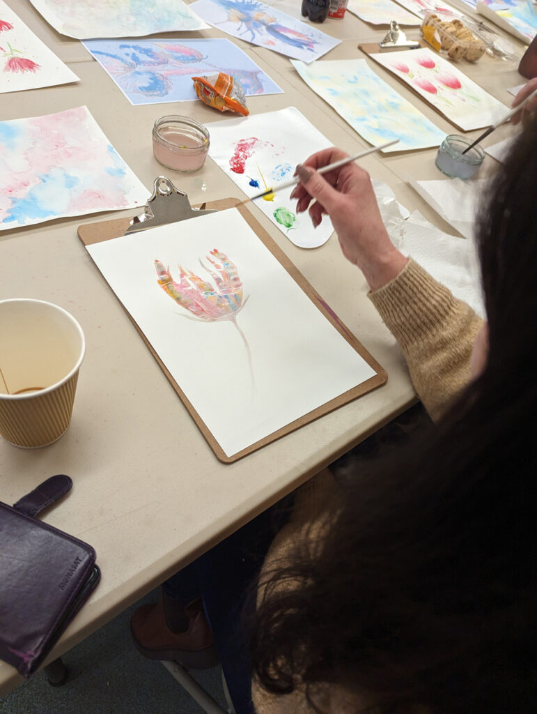 A close-up of someone painting a flower
