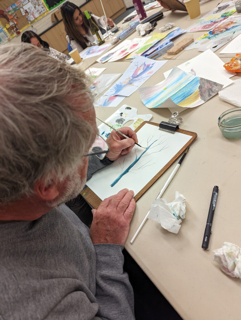A close-up of a man painting a tree