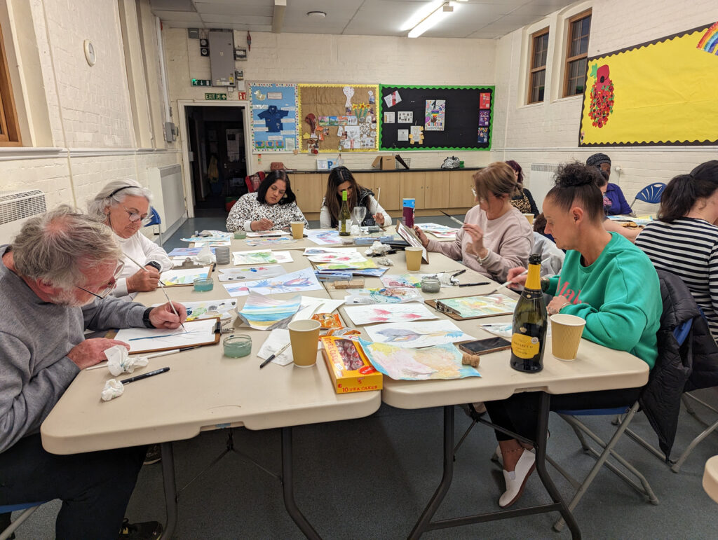 A table of people painting on paper