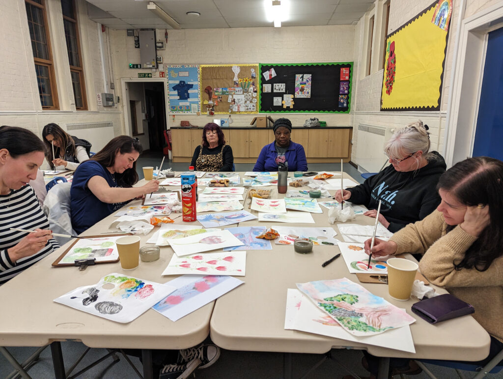A table of people painting on paper