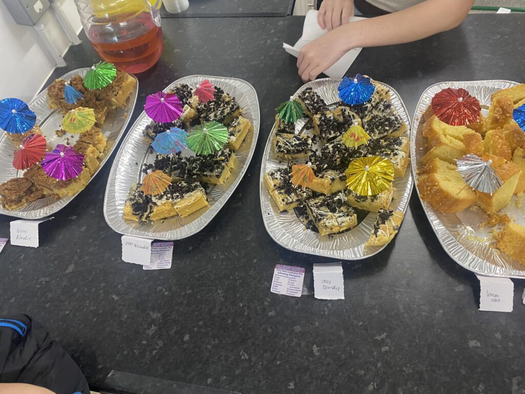 Several trays of cakes with decorative umbrellas