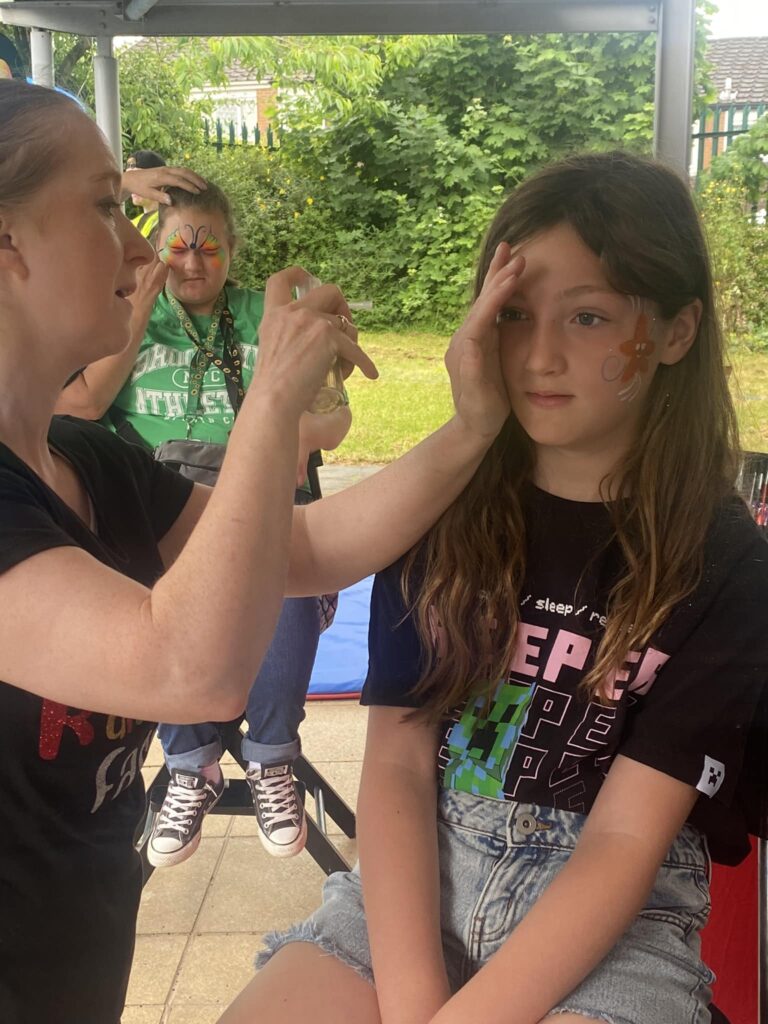 A child sitting still while getting their face painted