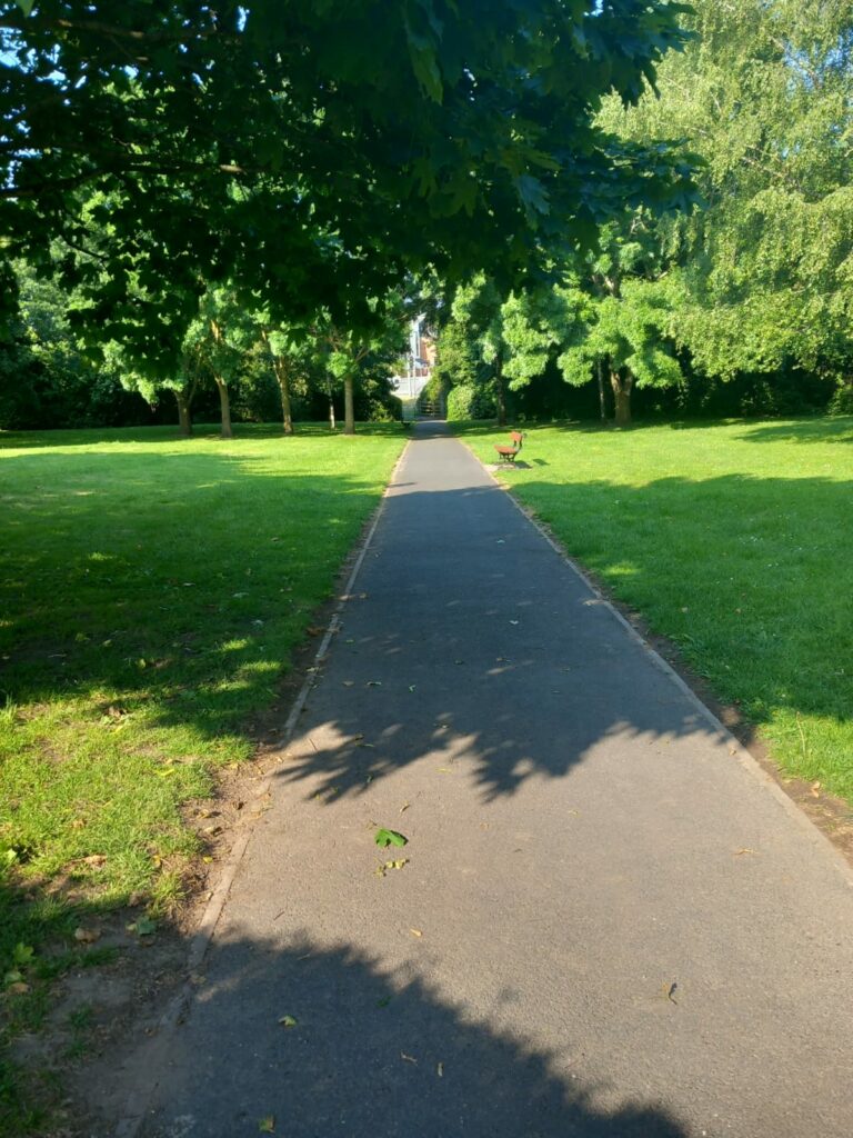 A photo of a long, straight footpath, with freshly-trimmed grass on either side