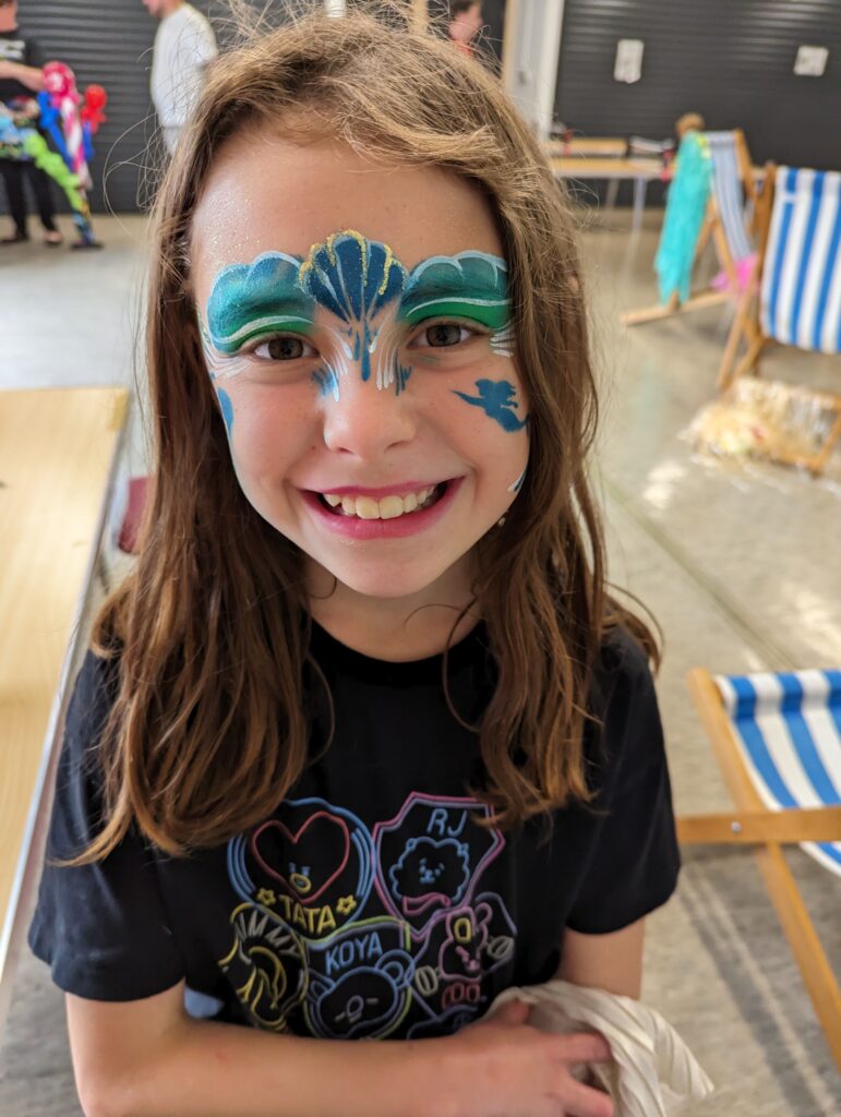 A child with face paints smiling for the camera