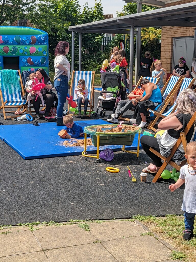 An assortment of deck chairs with people sitting outside, and an inflatable toy at the back