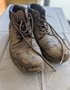 pair of old boots covered in mud